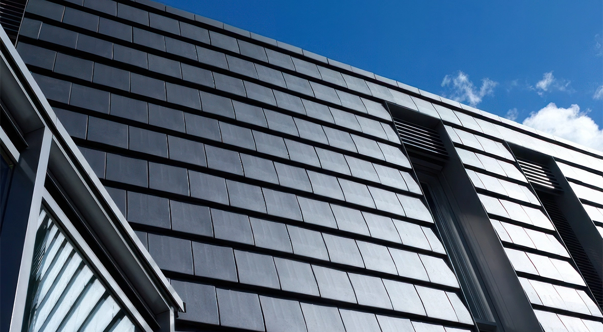 Sloped roof with dark tiles, set against a clear blue sky (photo)