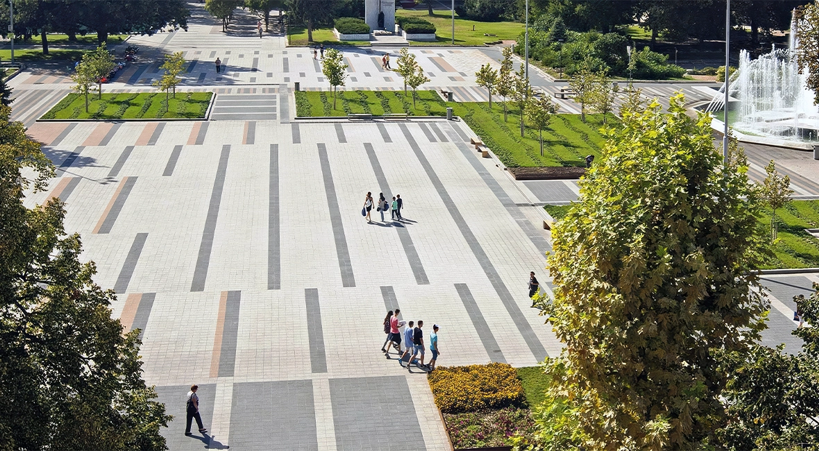 Public square with abundant greenery and a fountain on the right side (photo)