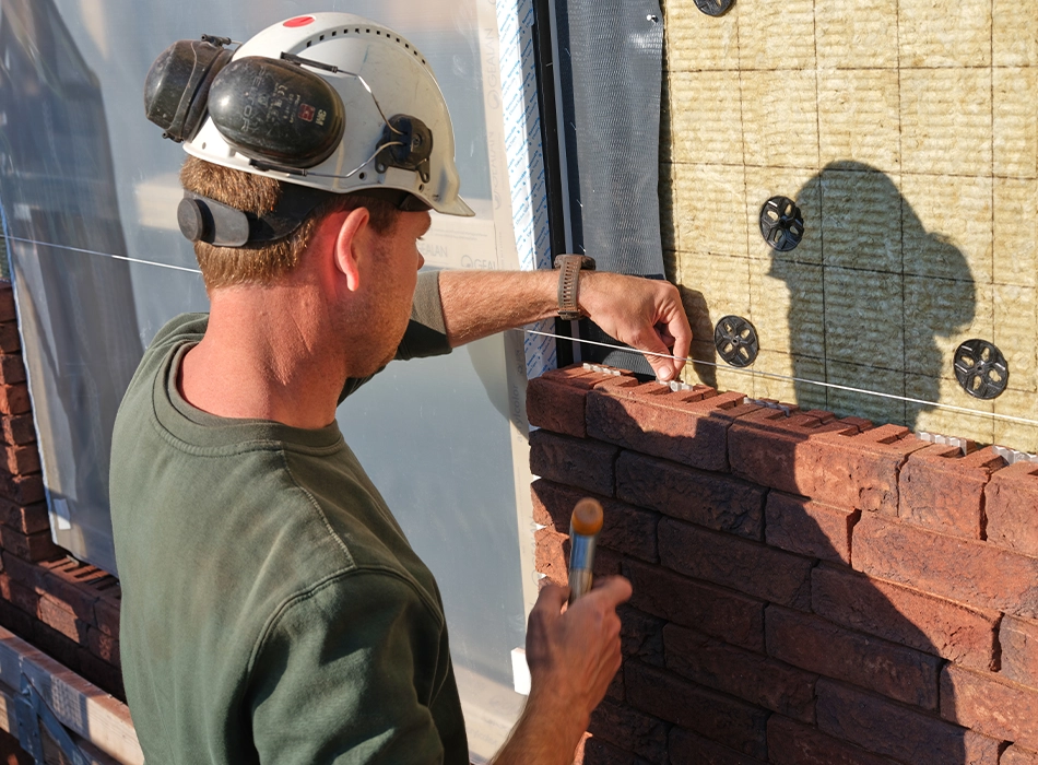 A worker lays bricks during the renovation and extension of the historic Orangery in Baarn, the Netherlands, using the wienerberger ClickBrick system (photo)