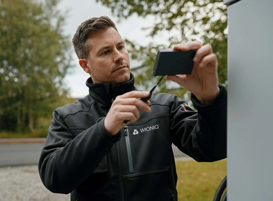Man in workwear operating a handheld device (photo)