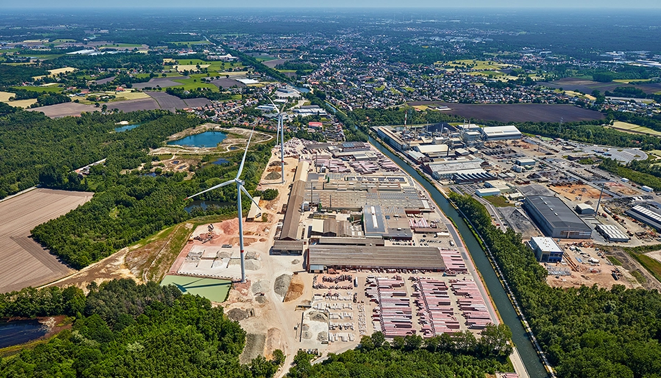 Aerial view of the wienerberger brick plant in Beerse, Absheide, with two wind turbines on the site next to the canal and a small forest. (photo)