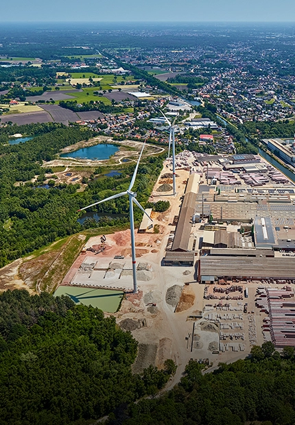 Aerial view of the wienerberger brick plant in Beerse, Absheide, with two wind turbines on the site next to the canal and a small forest. (photo)